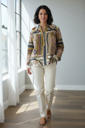 A person with blonde, shoulder-length hair is shown from the back against a plain light background, wearing the STORIATIPIC - MARGOT BLOUSE IN DELYS by STORIATIPIC—a colorful, patterned long-sleeve blouse crafted from 100% cotton for comfort and breathability. This top pairs effortlessly with light pants and is ideal for gentle machine wash and easy cotton care.