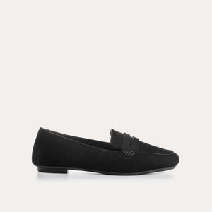 The REQINS HEMA Suede Loafer in Noir features a classic black silhouette, low heel, leather insole, and decorative front strap, shown against a plain light background.