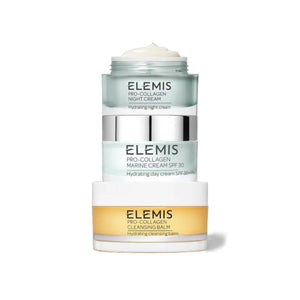 A dark textured rectangular box stands beside three stacked skincare containers labeled "ELEMIS." The ELEMIS - PRO-COLLAGEN HEROES GIFT SET by ELEMIS - STEINER includes a cleansing balm, day cream, and night cream for hydration.