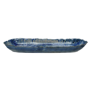 The CREATIVE COOP BLUE STONEWARE ORGANIC-SHAPED PLATTER features a wavy, textured edge and is shown from top and side angles. Its hand-crafted appeal is enhanced by a reactive crackle glaze in blue with white accents.
