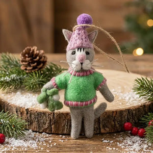 A FELT SO GOOD MISTLETOE MEOW ORNAMENT, a sustainable handcrafted needle-felted gray cat wearing a pink knit hat and green sweater, holding a sprig of mistletoe for festive decor.