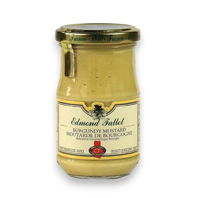 A glass jar of THE FRENCH FARM EDMOND FALLOT - BURGUNDY MUSTARD, made in France, featuring a gold lid and a cream-colored label that displays the product name in both French and English.