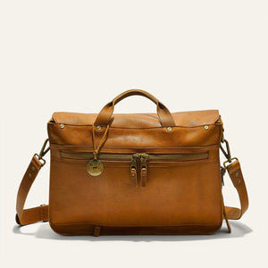 The WILL LEATHER GOODS - KENT MESSENGER BAG IN TAN features full-grain leather, a top handle, front flap with metal clasp, adjustable shoulder strap, and a laptop sleeve, shown against an off-white background.