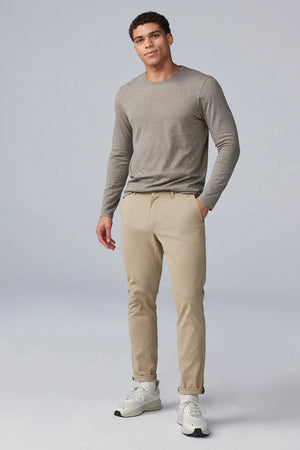 The MACK WELDON - MAVERICK TECH CHINO is a beige, stain-resistant pair of chinos with a straight-leg cut, button closure, and side pockets, shown laid flat on a white background.