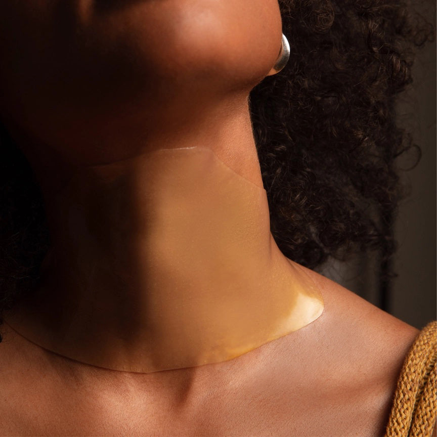 The LAPCOS - HYDRA COLLAGEN NECK MASK comes in a mint green box adorned with abstract white and beige lines. The packaging is labeled &quot;Hydra Collagen Replenishing Hydra-Gel Neck Mask,&quot; enriched with Marine Collagen and Hyaluronic Acid, with the brand name &quot;LAPCOS&quot; printed at the bottom.