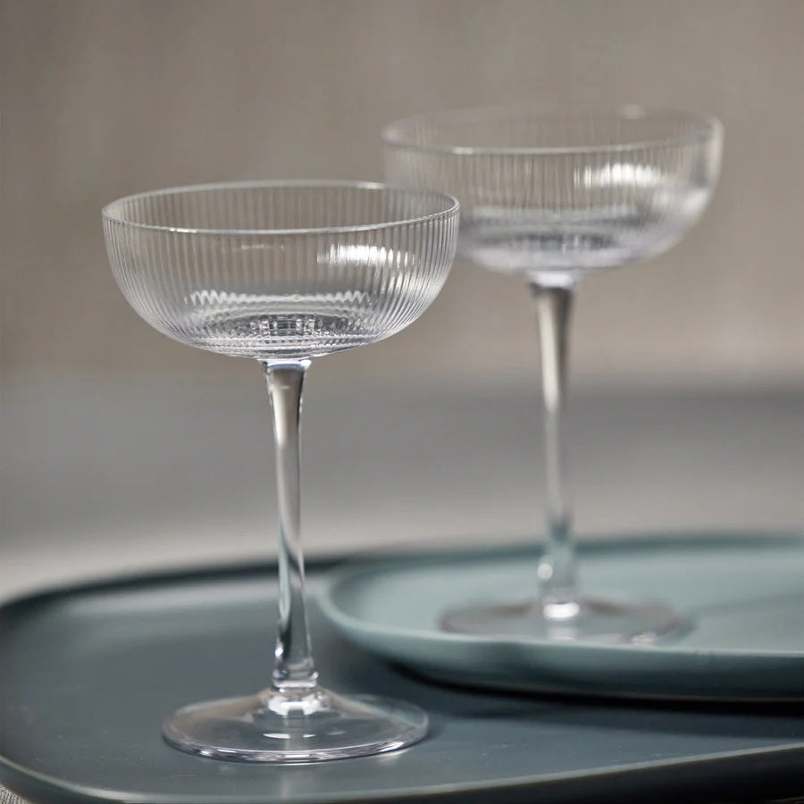 The ZODAX OPTIC DESIGN MARTINI GLASS, with its wide, shallow bowl and slender stem, stands upright against a white background—ideal for modern bars or as an elegant martini glass alternative.
