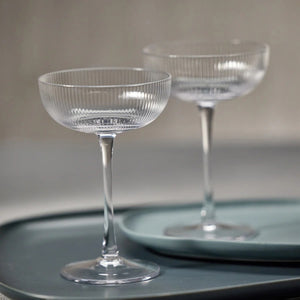 The ZODAX OPTIC DESIGN MARTINI GLASS, with its wide, shallow bowl and slender stem, stands upright against a white background—ideal for modern bars or as an elegant martini glass alternative.