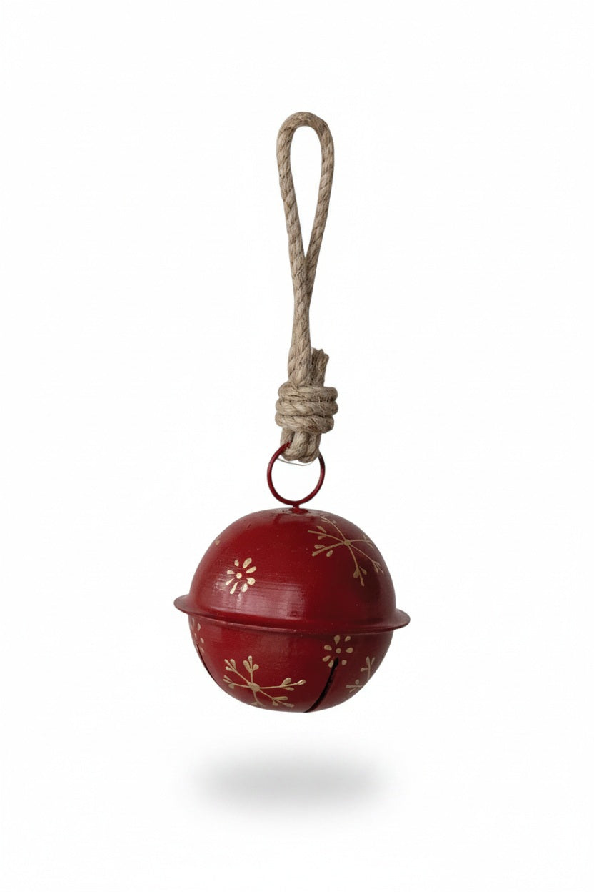 Creative Co-op JINGLE BELL ORNAMENT WITH SNOWFLAKES, a red spherical metal bell featuring gold snowflake designs, hanging from a rustic jute loop.