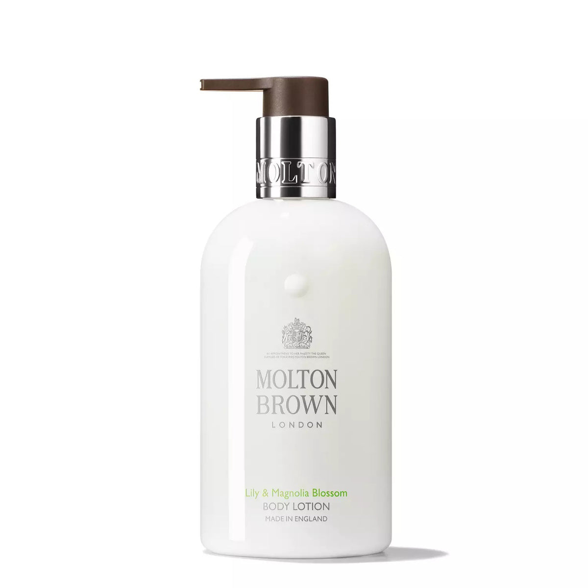 A white bottle of MOLTON BROWN - LILY AND MAGNOLIA BODY LOTION features a dark pump dispenser. The label reads "Lily &amp; Magnolia Blossom Body Lotion, Made in England." This lavish formula hydrates and comforts your skin. The bottle boasts a sleek and elegant design, complemented by a silver and dark brown lid.