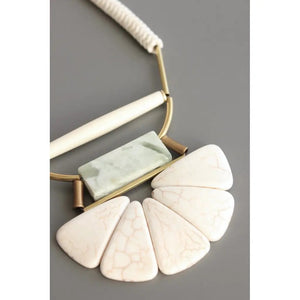 The DAVID AUBREY - WHITE STONE AND JADE LOTUS NECKLACE features five white magnesite pendants with subtle veining, a rectangular jade accent, and metal details—an elegant artisan piece by DAVID AUBREY.