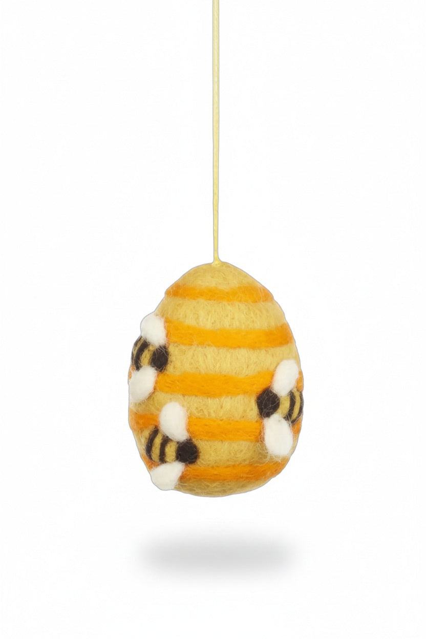 BUSY BEE HIVE ORNAMENT made of egg-shaped colourful wool felt with yellow and orange stripes, decorated with three small bees and featuring a jute twine loop for hanging.
