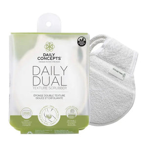 The packaging and product of the DAILY CONCEPTS DUAL TEXTURE SCRUBBER emphasize its ability to provide a gentle cleanse and mild exfoliation for skincare. Key benefits such as gentle cleansing, exfoliation, and smart technology for product writing are highlighted on the packaging, with the scrubber visible through it.
