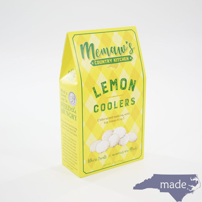 A yellow and green diamond-patterned box labeled "MEMAWS COUNTRY KITCHEN - LEMON COOLERS" from the brand 1 IN 6 SNACKS is pictured. The box displays images of sweet and zesty lemon cookies dusted with sugar. A blue silhouette of North Carolina with the word "made." is in the bottom right corner.