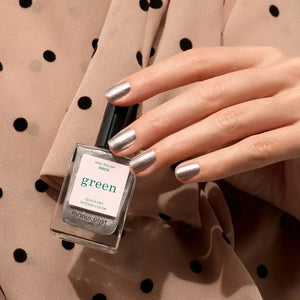 A transparent glass bottle of MANUCURIST - GREEN™ Nail Polish in Disco by MANUCURIST INC contains a sparkling silver glitter vegan polish. The bottle features a black cap and a white label adorned with green and black text.