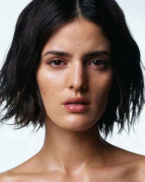 A gray tube of U BEAUTY THE PLASMA LIP COMPOUND 15ML, a hydrating lip treatment with a ribbed cap and minimalist design, stands upright against a white background.