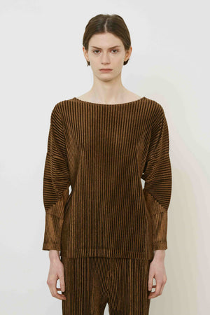 A person with short brown hair stands sideways in a MEIMEIJ - PLEAT TOP by MEIMEIJ against a plain white background, highlighting modern Italian fashion.