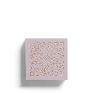 The ROSE ET MARIUS - SUNLIT ROSE WATER SCENTED SOAP GIFT BOX features a pastel pink square soap bar with an ornate, symmetrical floral design and carved swirls, displayed on a white background with shadows to the left and bottom.