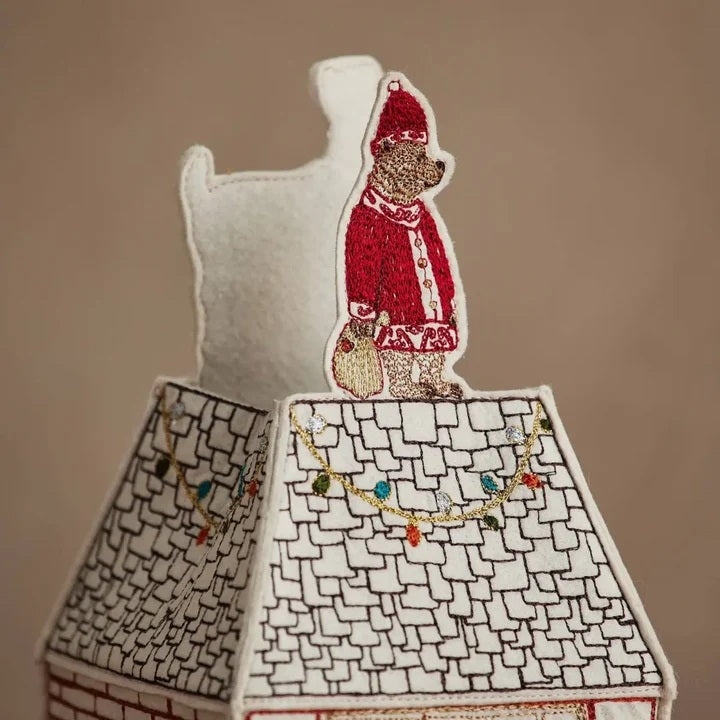 HOME FOR THE HOLIDAYS TISSUE BOX COVER shaped like a house, featuring an embroidered Christmas tree, string lights, and a teddy bear in a Santa hat for festive holiday home decor.
