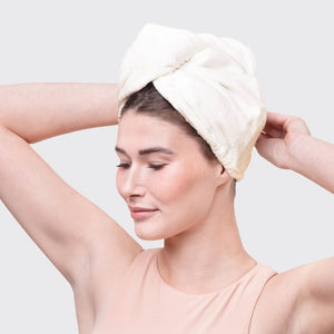 The KITSCH - QUICK DRY HAIR TOWEL, made from organic cotton and bamboo, features eco-friendly packaging with a teardrop design that promises frizz reduction for fine, curly, or straight hair. It includes an image of a person wearing the towel.