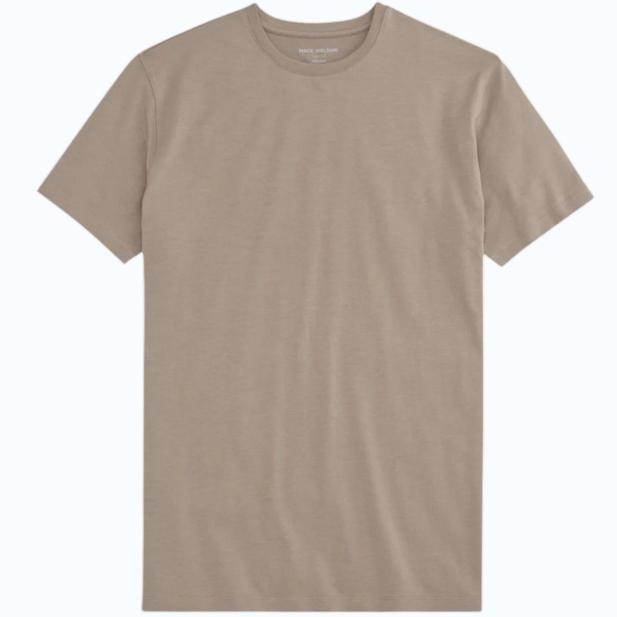 A man with short dark hair and a beard wears the Mack Weldon Silver Crew Neck T-Shirt in Desert Taupe, paired with dark jeans and a wristwatch. He stands against a light gray background, looking slightly to the side with a neutral expression.