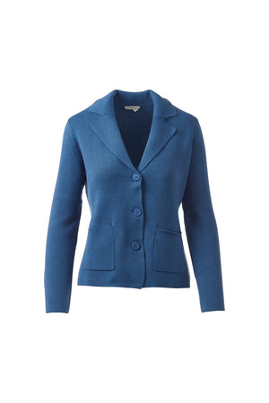 A woman stands confidently against a white background, wearing the KINROSS CASHMERE E-Fitted Notch Collar Cardigan in Cotton Sapphire over a white top and black pants. Her short hair is pulled back and she has a slight smile.