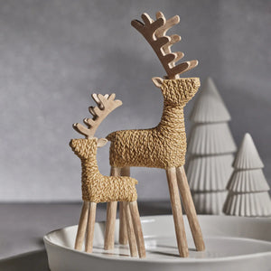 The ZODAX STANDING DEER 9.5 is a decorative 4" x 9.5" reindeer figurine made from textured natural materials, featuring a woven body, wooden legs, and stylized antlers, standing upright on a white background.