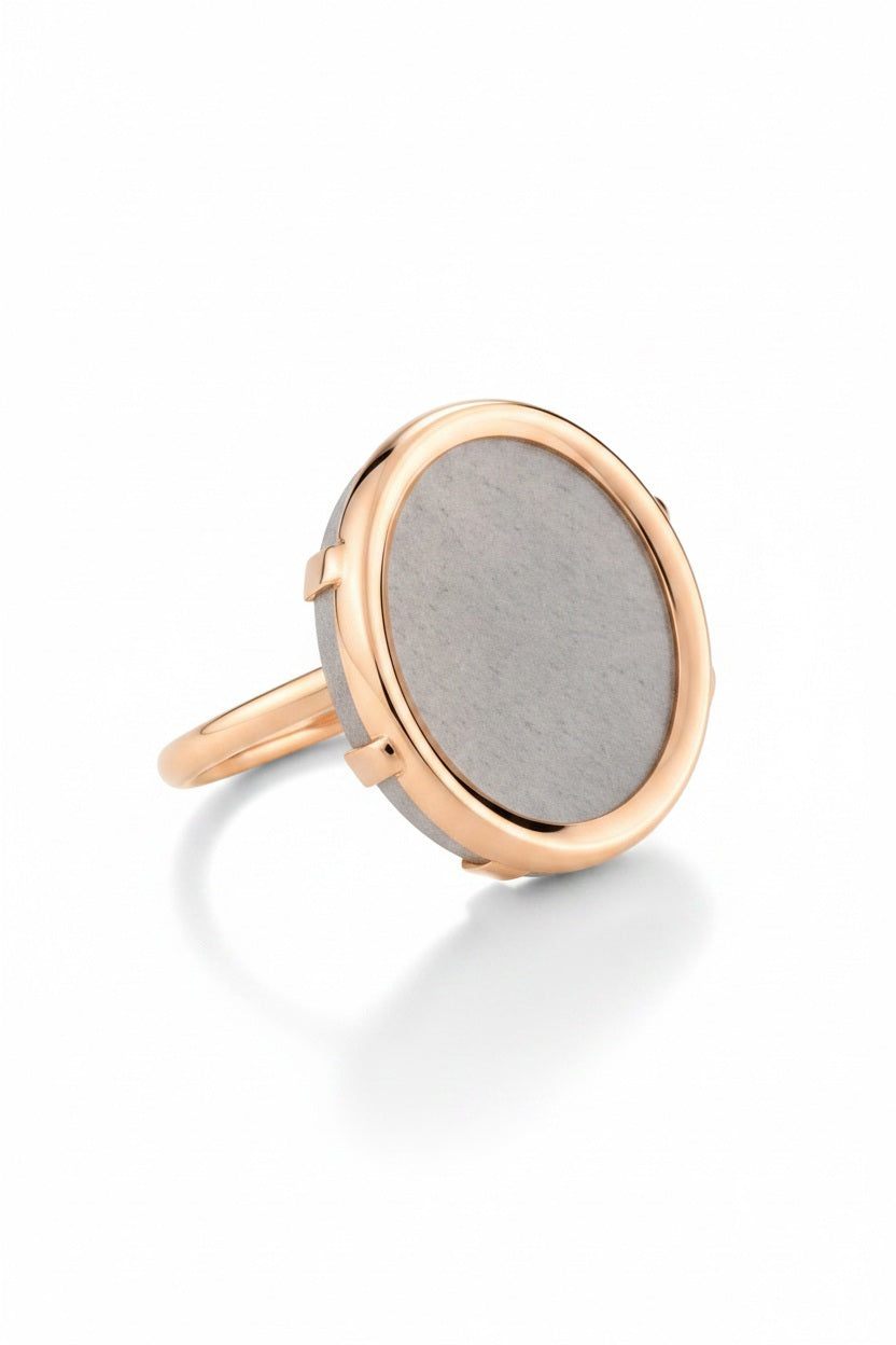 The EVER MOONSTONE 18K ROSE GOLD (7) ring by GINETTE NY features a large round gray moonstone set in a simple bezel on a thin 18K rose gold band, offering an elegant and modern accessory for contemporary jewelry lovers.