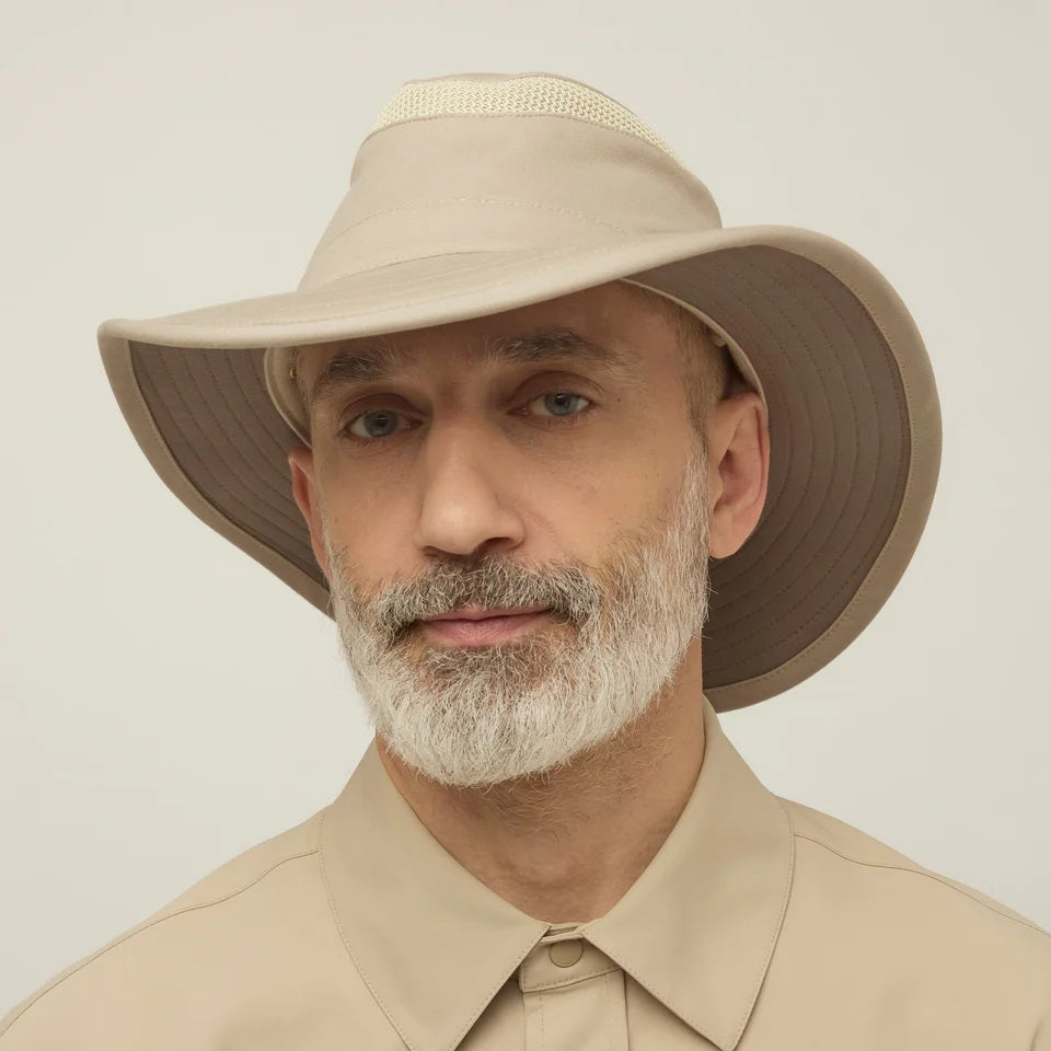 A man with a gray beard wears the TILLEY - AIRFLO HIKERS HAT T4MO-1 IN KHAKI OLIVE, featuring UPF 50+ sun protection, and a matching collared shirt, shown in profile against a plain light background.