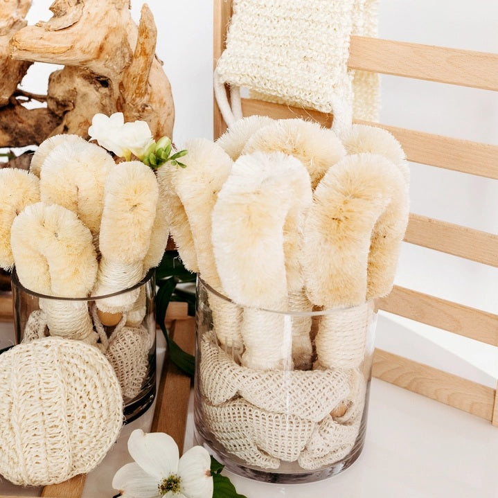 Introducing the BAUDELAIRE - SISAL 9” BODY BRUSH by BAUDELAIRE—a natural sisal body brush featuring a sturdy wooden handle, convenient rope loop, and dense pale bristles. Ideal for exfoliating and dry brushing, this brush is finished with a tag that reads “Baudelaire Sisal Brush.”.