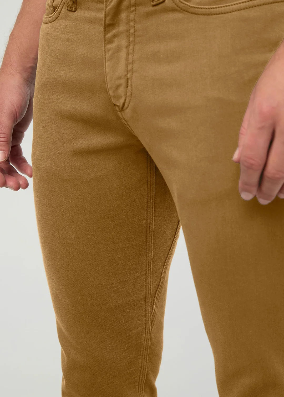Close-up of the back of a person wearing the DUER No Sweat Straight Pants in Caramel, featuring stitched back pockets and a black DUER brand label on the waistband, crafted from DUER’s innovative No Sweat fabric for exceptional comfort.