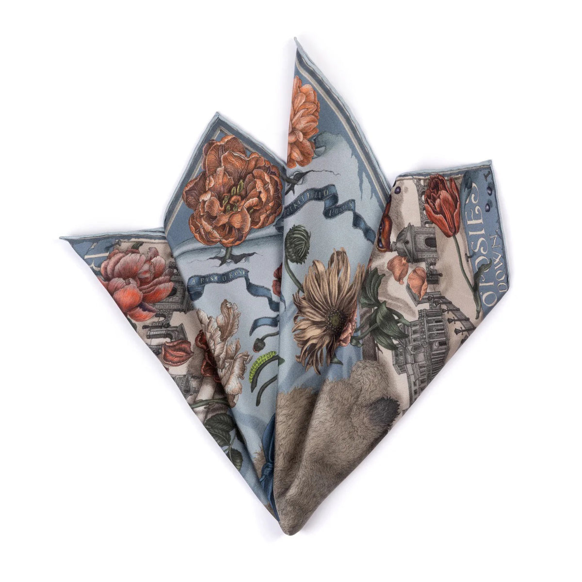 A woman holds the SABINA SAVAGE "Ring a Ring o' Roses" silk twill scarf in Glacier/Ballet, featuring a blue-eyed cat with a ribbon amidst Victorian botanicals and a historic building backdrop, with "Ring a Ring o' Roses, A Pocket Full of Posies" elegantly displayed.