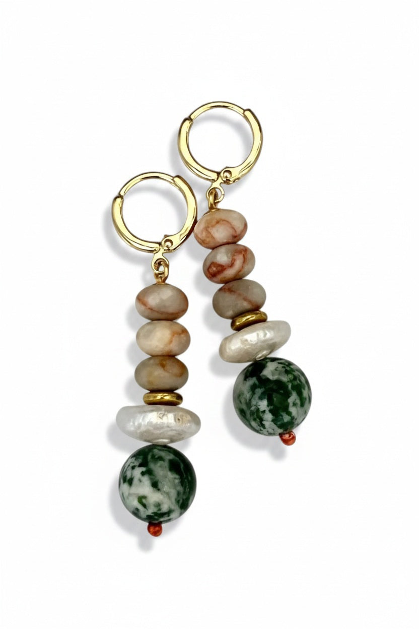 The SELENA EARRINGS by SANDRINE FRANCE STUDIO are gold hoops with stacked beige and brown marbled beads, a white pearl-like accent, gold spacer, and a large green-and-white Tree Agate bead, displayed on a plain background.