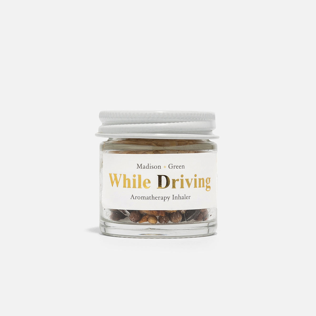 A small glass jar with a white lid labeled "MADISON GREEN - WHILE DRIVING STRESS RELIEF AROMATHERAPY INHALER," featuring a blend of organic essential oils and botanicals for stress relief, set against a plain white background.