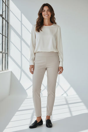 Wearing the KRAZY LARRY, INC PULL ON STRAIGHT LEG MICROFIBER PANT in white, paired with a dark patterned top and red shoes, a person poses against a white background. The image features only the lower half of their body, highlighting this chic office-ready style.