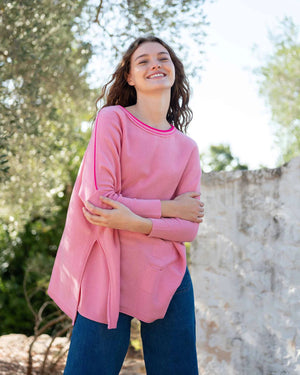 Woman wearing the MERSEA - CATALINA CREWNECK SWEATER, white with two black stripes, paired with denim shorts and a gold necklace—an essential piece from MERSEA for effortless, versatile style.