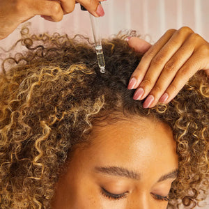 A brown glass bottle labeled "KITSCH - 100% CASTOR OIL" is set between a black mascara wand and a clear oil dropper. Renowned for supporting hair growth and moisturizing cuticles, this beauty essential is displayed on a plain white background.