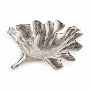 The NAPA HOME AND GARDEN - FOLIA DECORATIVE SILVER TRAY is a silver, leaf-shaped dish featuring detailed veins and a textured surface. It showcases natural leaf design with a stem on one end, offering an elegant silver finish.