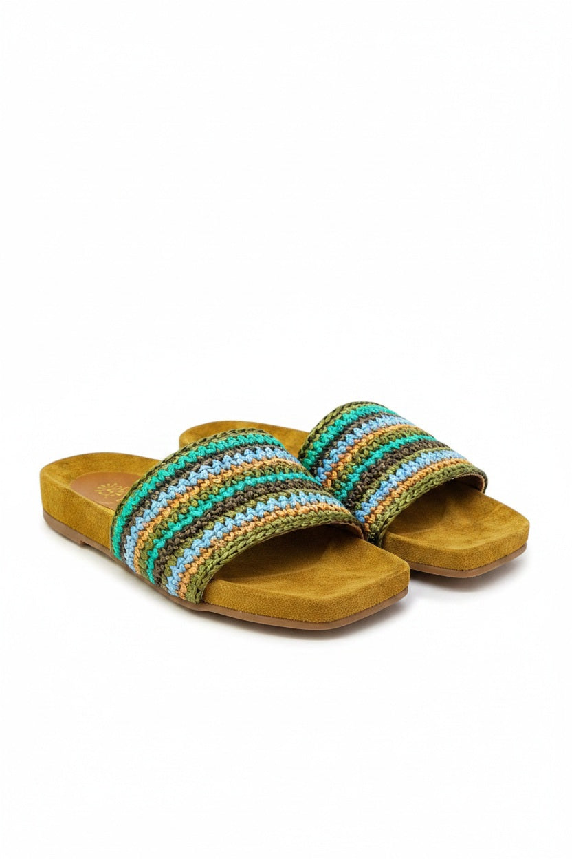The DA SIENA - LUCILLA RAFIA SLIDE by DE SIENA features open-toe sandals with brown suede soles, a comfy eco footbed, wide multicolored woven straps in green, blue, yellow, and brown stripes, and a branded floral "DE SIENA" insole.