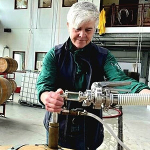 A metal sign reading "red tail ridge" with a tree and bird sculpture stands on grass at sunset—an inviting welcome to the Red Tail Ridge Wine Dinner by FEARRINGTON VILLAGE, perfect for a Finger Lakes wine experience.