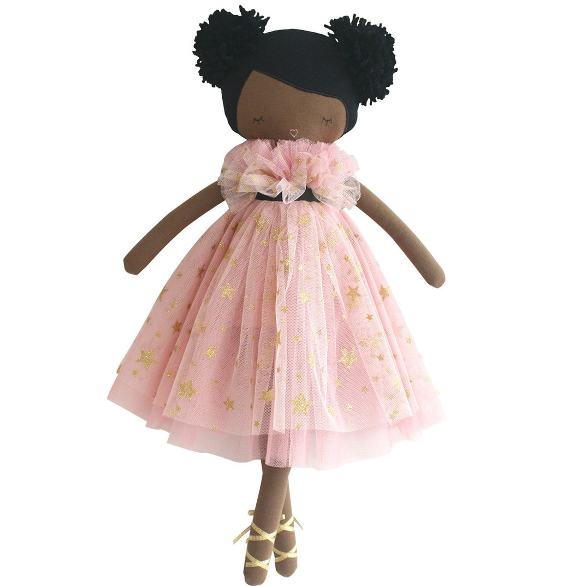 The ALIMROSE MAE Doll Blush Gold Star by ALIMROSE features a handmade design with brown skin and adorable pom-pom hair styled in two puffs. She is dressed in a blush pink tulle dress adorned with gold stars, cinched at the waist with a black ribbon. She completes her enchanting look with ballet-style shoes and an embroidered face accentuated by charming details.
