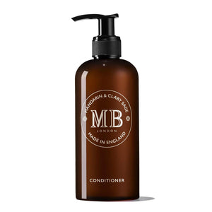 A dark amber bottle features a sleek black pump dispenser. The label prominently displays "MOLTON BROWN" in large letters, encircled by "Mandarin & Clary Sage" and "Made in England." At the bottom, the word "Conditioner" is clearly highlighted, indicating it as part of the FEARRINGTON LIFESTYLE COLLECTION - MOLTON BROWN 1971 Collection. This luxurious botanical hair conditioner is enriched with mandarin peel extract.
