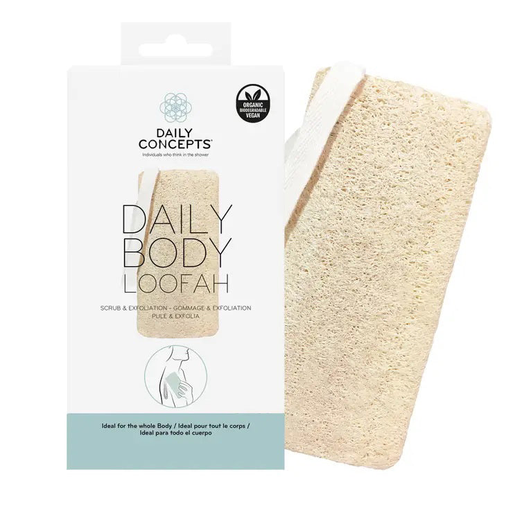 Image of the DAILY CONCEPTS BODY LOOFAH product in its packaging. The white packaging displays an image of the loofah, text describing it as a gentle exfoliation tool, and logos signifying its organic and vegan qualities. The biodegradable, rectangular loofah has a coarse texture.