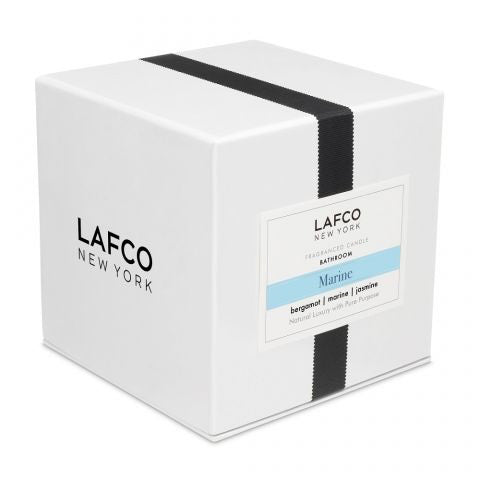 A photo of the LAFCO - MARINE, BATHROOM 6.5OZ cylindrical glass candle holder by LAFCO, featuring a light teal and white ombre design reminiscent of marine hues. The candle holder casts a soft shadow against a plain white background.