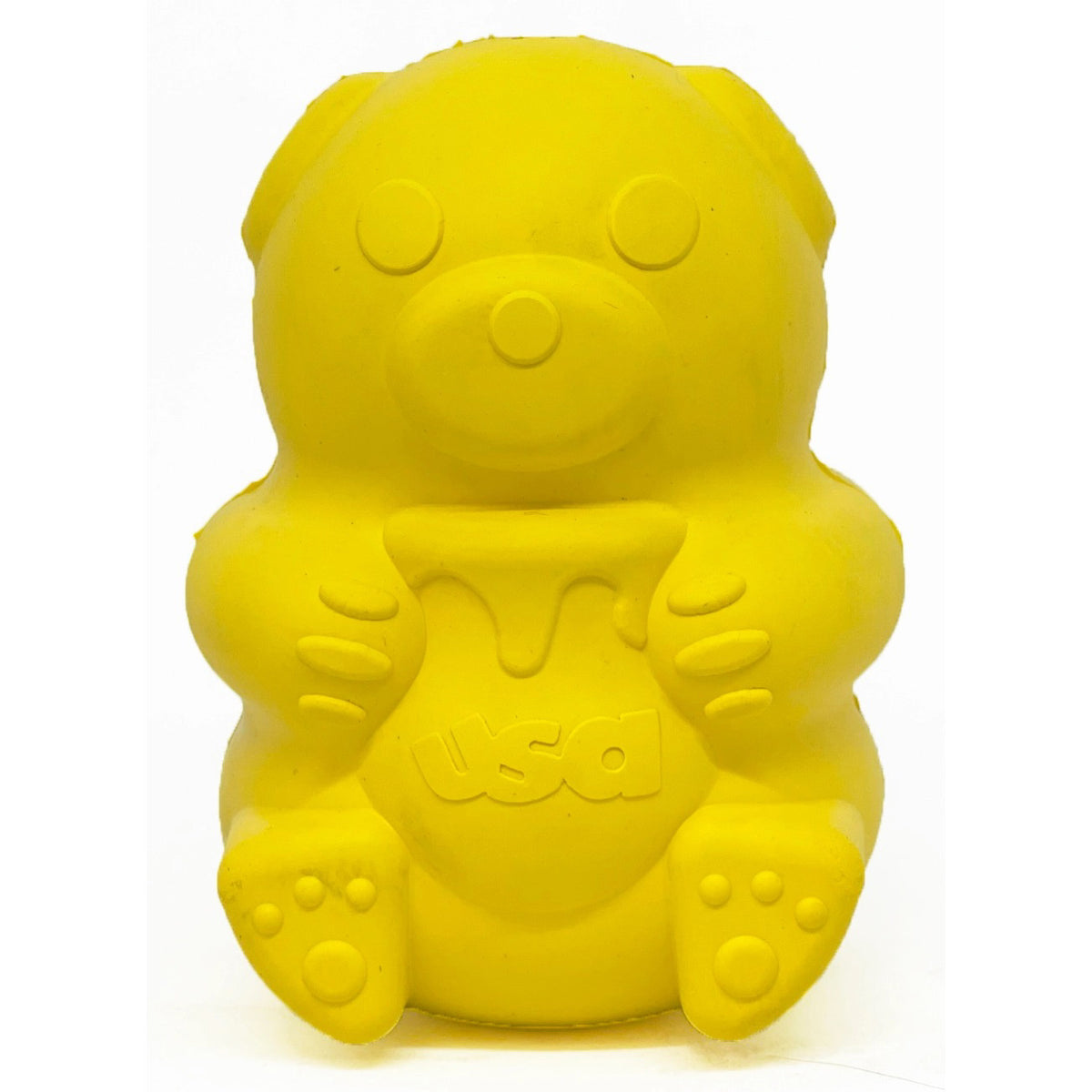 The TREAT DISPENSER HONEY BEAR (L) by SODA PUP is a durable, bright yellow rubber bear toy that holds a jar labeled &quot;USA&quot; with a dripping honey design. Made in the USA, it features rounded ears, circular eyes, a small nose, and detailed paws. This chew toy is also designed to dispense treats.