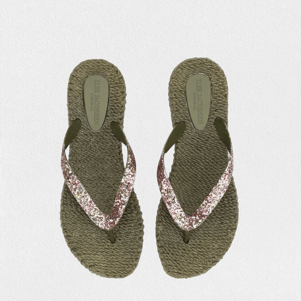 The LINES OF DENMARK ILSE JACOBSEN CHEERFUL FLIP FLOPSIN ARMY GLITTER feature green braided soles and shiny black and pink glittery straps adorned with glitter stones, displayed on a plain white background.