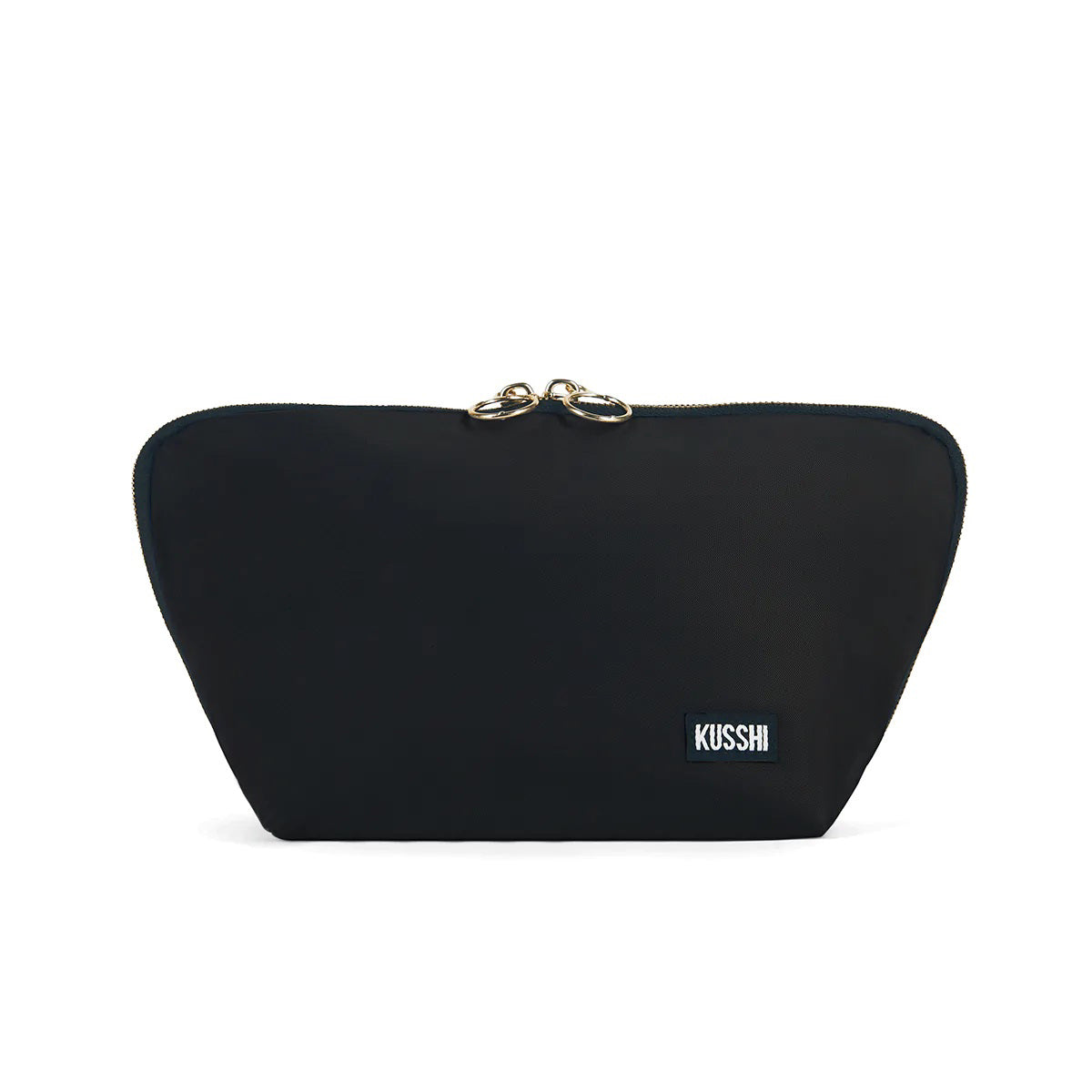 Presenting the KUSSHI - Signature Makeup Bag in Black: a stylish, zippered makeup bag with a rectangular shape and a slightly curved top. The pouch is adorned with two gold zipper pulls and features a small rectangular label with &quot;KUSSHI&quot; written in white letters on the bottom right corner. It offers spacious compartments and is conveniently machine washable for easy care.