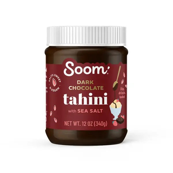 A jar of SOOM - DARK CHOCOLATE SEA SALT TAHINI. The maroon label from SOOM FOODS features illustrations of chocolate, a sesame plant, and a small chocolate dessert. This 12-ounce (340 grams) jar with a white lid contains delectable sesame tahini blended with cocoa powder. It is nut-free, gluten-free, and vegan.
