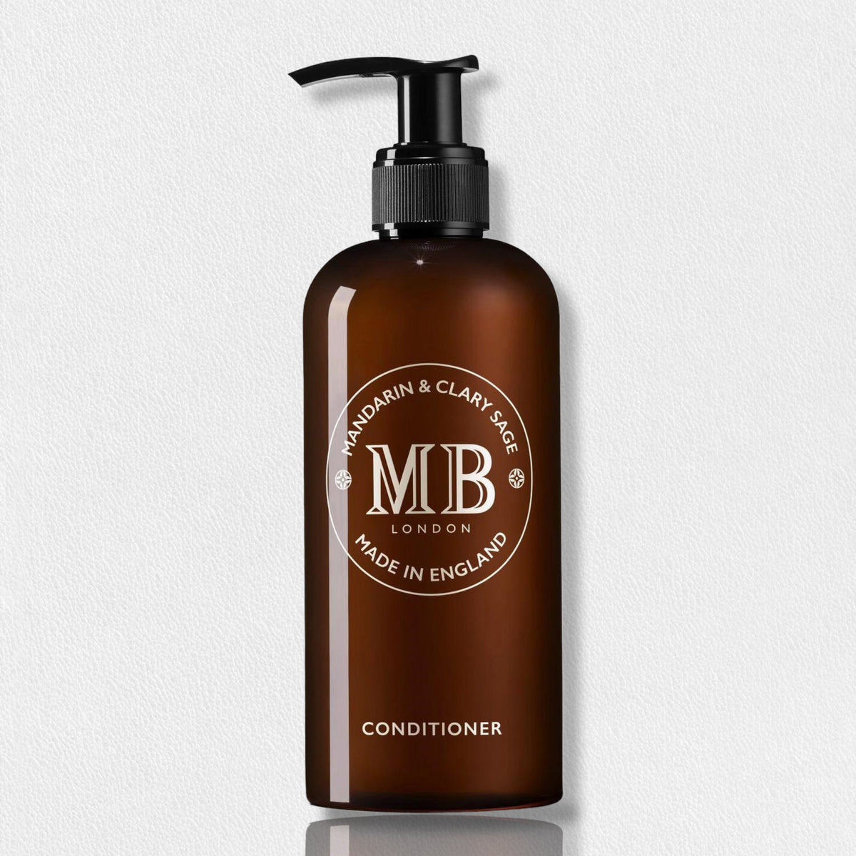 A dark amber bottle features a sleek black pump dispenser. The label prominently displays &quot;MOLTON BROWN&quot; in large letters, encircled by &quot;Mandarin &amp; Clary Sage&quot; and &quot;Made in England.&quot; At the bottom, the word &quot;Conditioner&quot; is clearly highlighted, indicating it as part of the FEARRINGTON LIFESTYLE COLLECTION - MOLTON BROWN 1971 Collection. This luxurious botanical hair conditioner is enriched with mandarin peel extract.