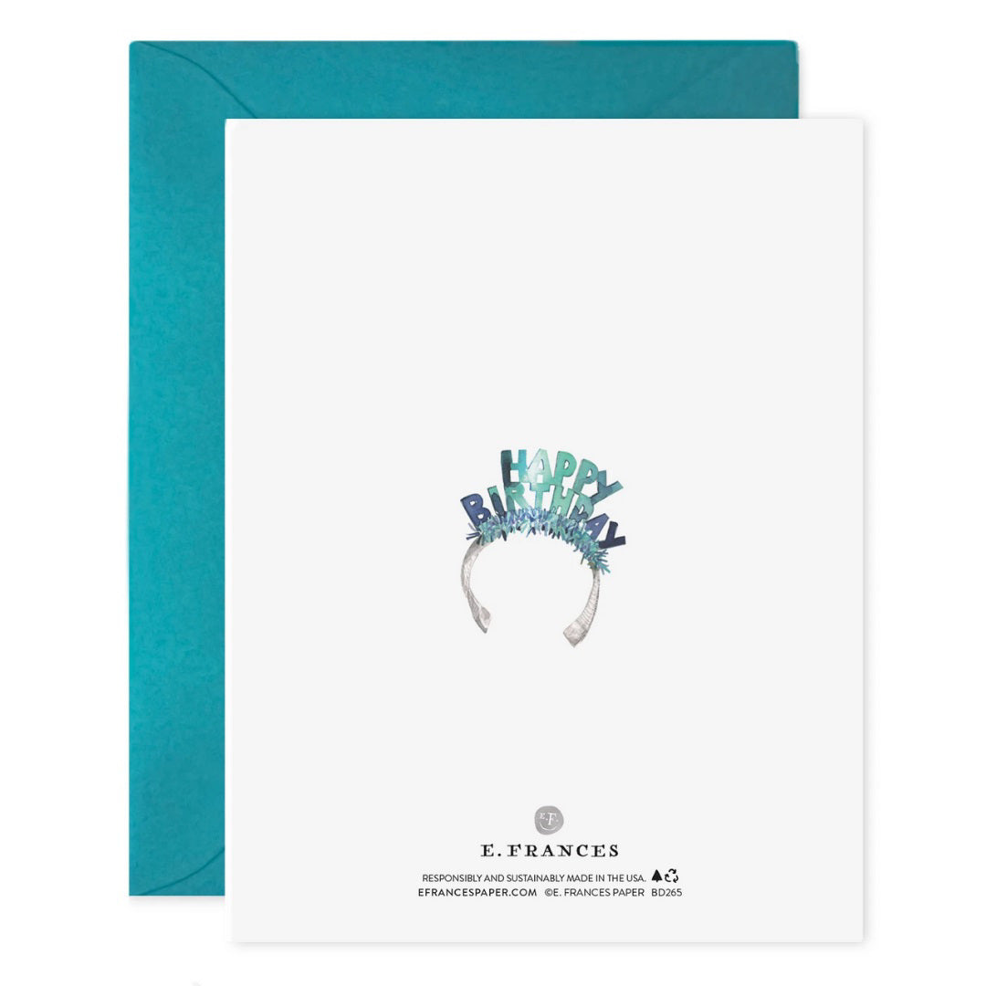 The E. FRANCES PAPER "Lucy Dog Birthday" card features a fluffy white dog in a blue birthday headband, paired with a teal envelope and printed on luxe heavyweight paper.
