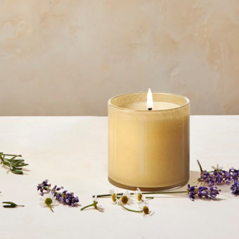 A small, cylindrical glass container filled with creamy yellow wax, resembling a candle. The unlit **LAFCO - BEDROOM CHAMOMILE LAVENDER 6.5OZ** by **LAFCO** casts a faint shadow on a white background and exudes a delicate hint of lavender.